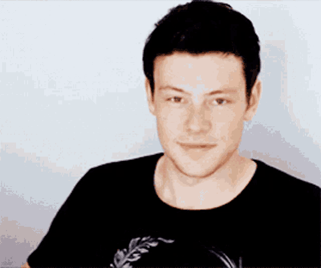 a man in a black shirt is smiling and asking how ya doing