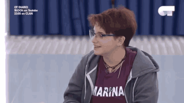 a woman wearing glasses and a marina t-shirt
