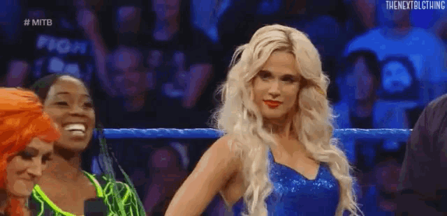 a woman in a blue dress is standing in a ring .