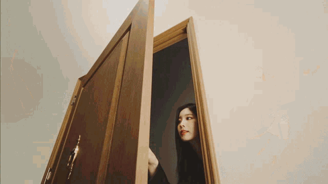 a woman stands in a doorway looking out
