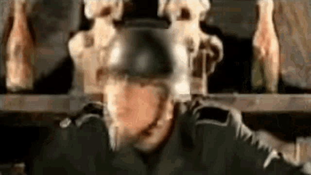 a soldier wearing a helmet is standing in front of a shelf with skulls on it .