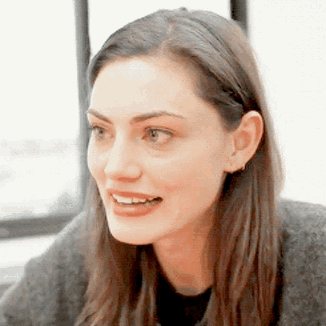 a close up of a woman 's face with a window in the background