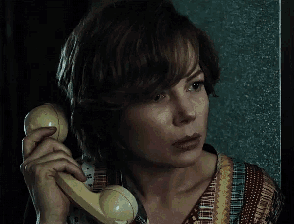 a woman talking on a telephone with a floral shirt on