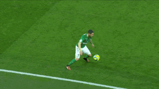 a blurry picture of a soccer game with one player wearing a blue shirt