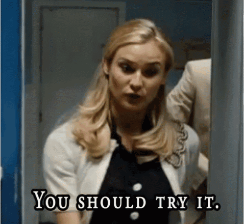 a woman is standing in a doorway saying you should try it .