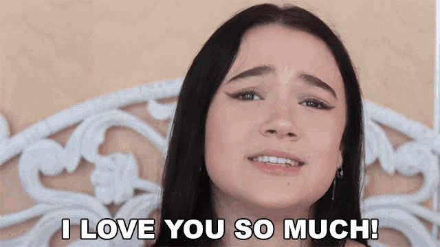 a woman says i love you so much in front of a bed