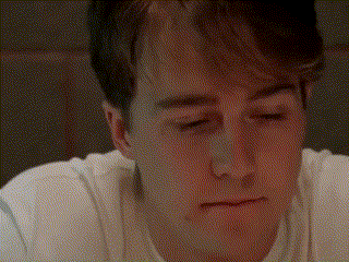a close up of a man 's face with his eyes closed and a white shirt on