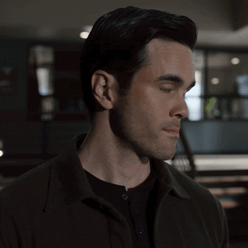 a man with a beard is wearing a black shirt
