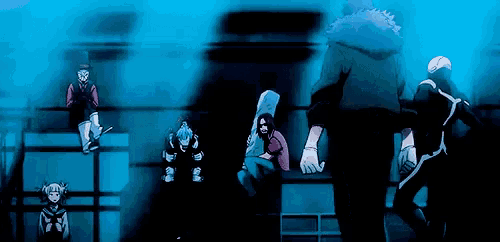 a group of people are standing in a dark room with a blue background .