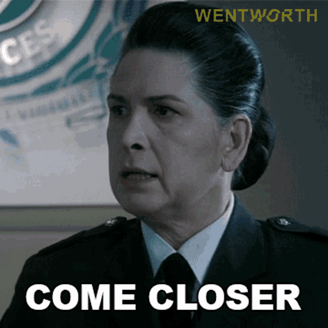 a woman in uniform says come closer in front of a sign that says wentworth