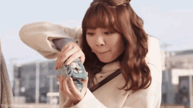 a woman in a white coat is holding a small box with a picture on it