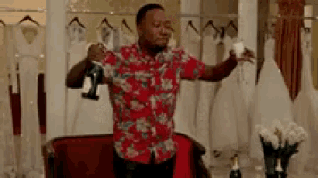a man in a hawaiian shirt is holding a glass of champagne