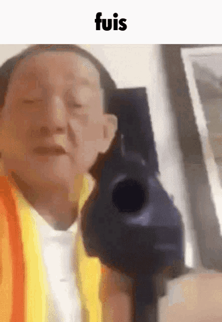 a man is pointing a gun at the camera with a caption that says ' fuis '