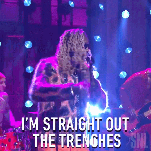 a man singing into a microphone with the words " i 'm straight out the trenches "