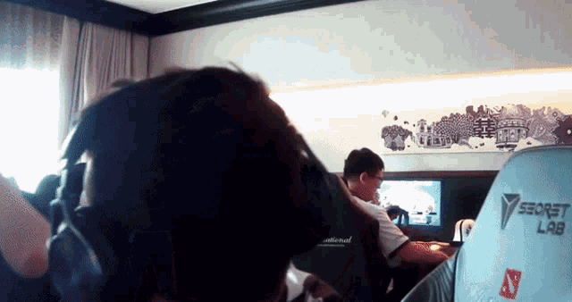 a man wearing headphones is sitting in a room with a secret lab chair