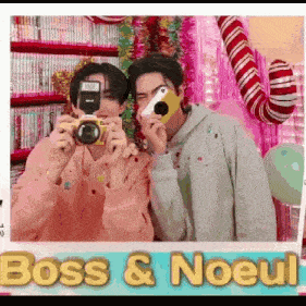 two men are taking a picture of each other with cameras .