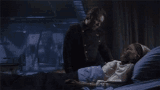 a man in a black uniform is standing next to a woman in a hospital bed