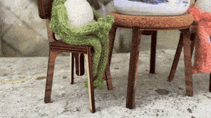 a chair with a green blanket on it sits next to a table