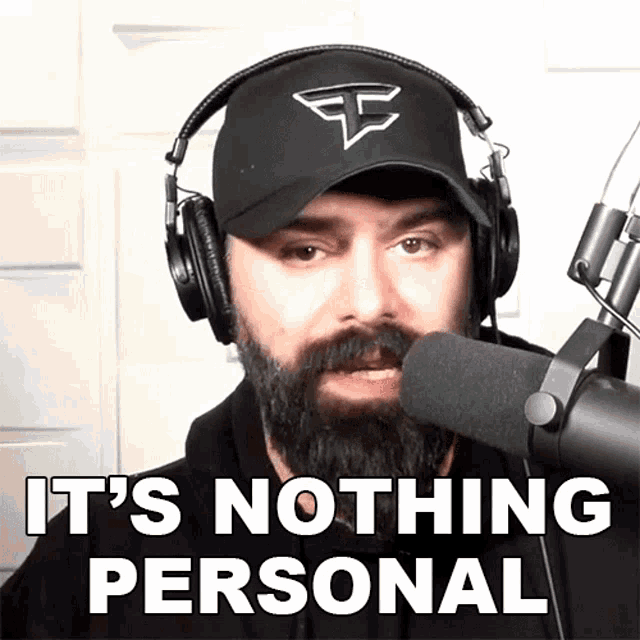 a man with a beard wearing headphones and a hat says " it 's nothing personal "