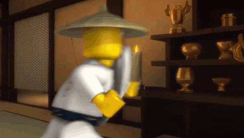 a lego man is holding a candle in a room with trophies on shelves .