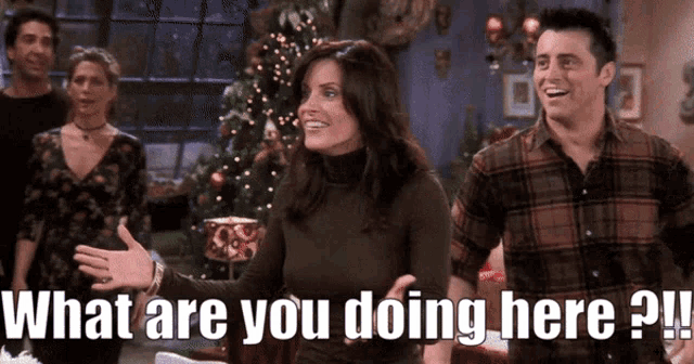 a man and a woman are standing in front of a christmas tree with the words what are you doing here