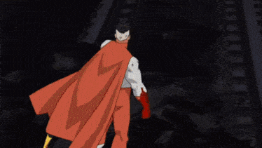 a man in a red cape is walking on a train track