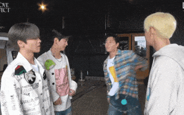a group of young men are standing in front of a sign that says " love object "