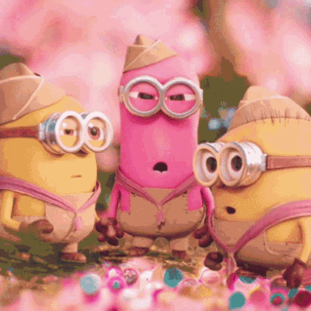 a group of minions standing next to each other with one wearing a pink outfit