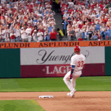 a baseball player with the number 33 on his jersey is running to base