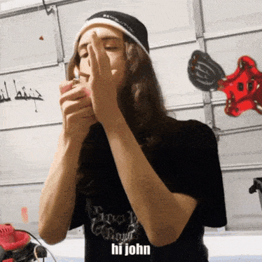 a man wearing a black shirt that says hi john on it