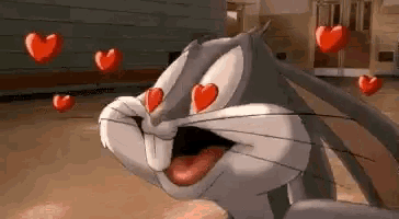 bugs bunny from looney tunes is in love with hearts flying around him .