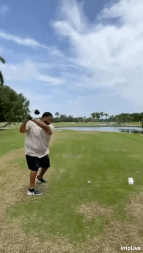 a man is swinging a golf club at a golf ball .