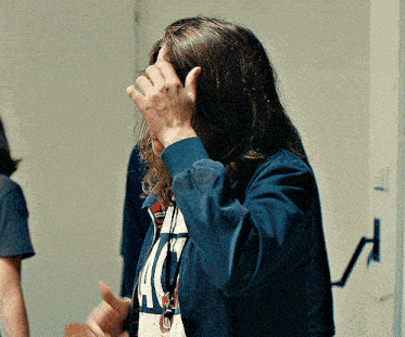 a woman with long hair is wearing a blue jacket and a t-shirt that says ' ucsd ' on it