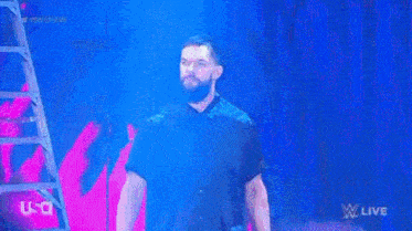 a man walking on a stage in front of a sign that says prince