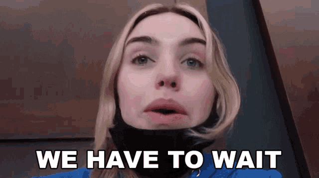 a woman wearing a black mask says we have to wait