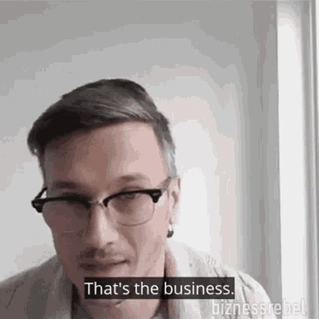 a man wearing glasses and earrings says `` that 's the business '' .