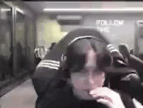 a man is sitting in a chair wearing headphones and looking at the camera .
