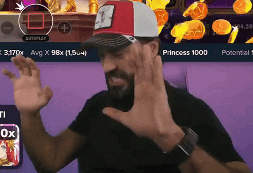 a man wearing a red and white hat is sitting in front of a screen that says ' autoplay ' on it
