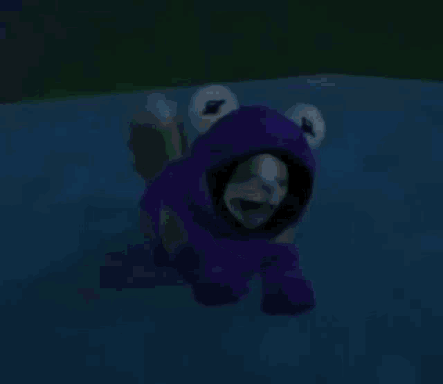 a cat is wearing a frog costume and swimming in a pool .
