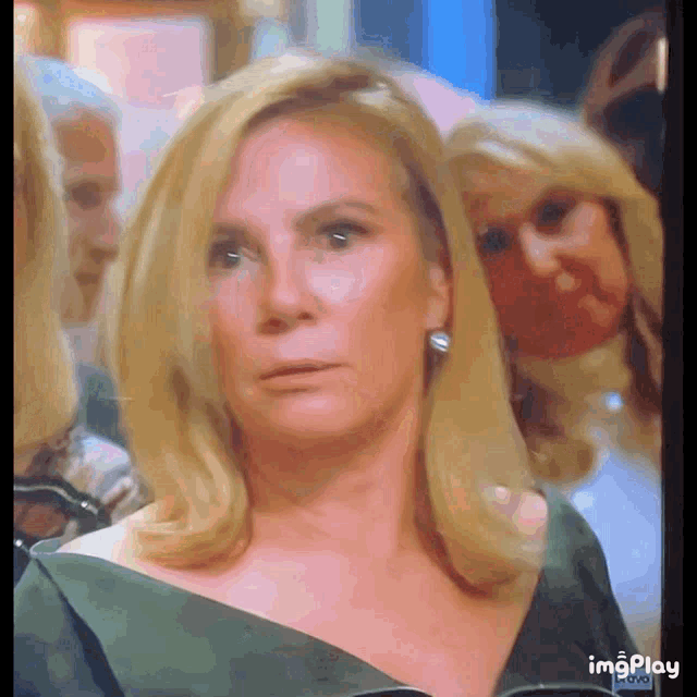 a woman in a green dress is looking at the camera