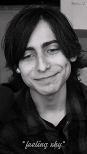a black and white photo of a young man with the words " feeling shy " below him