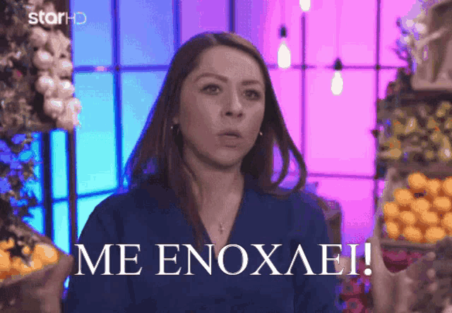 a woman in a blue shirt with the words me enoxaei