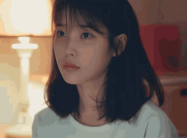 a woman in a white shirt looks at the camera