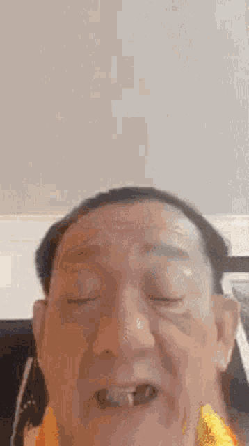 a close up of a man 's face with his eyes closed and his mouth open .