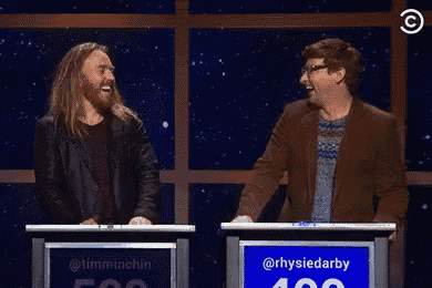 a man and a woman are giving each other a high five in front of a sign that says rhysiedarby