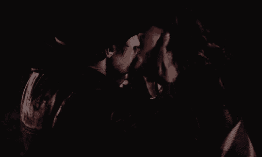 a man and a woman kissing in the dark