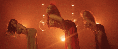 three women are dancing in a dark room