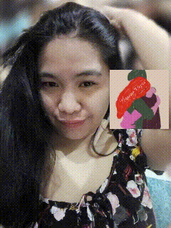 a woman in a floral dress holds her hair in front of a painting that says ' i love you '