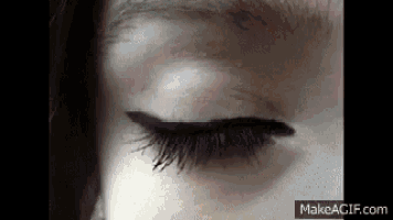 a close up of a woman 's eye with long eyelashes and eyeliner .