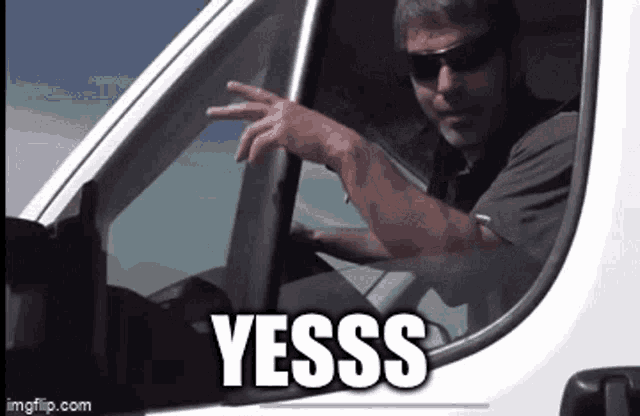 a man wearing sunglasses is driving a white van and pointing out the window with the words yesss above him